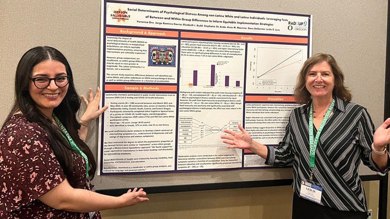 image of Leslie Leve with a student poster presentation